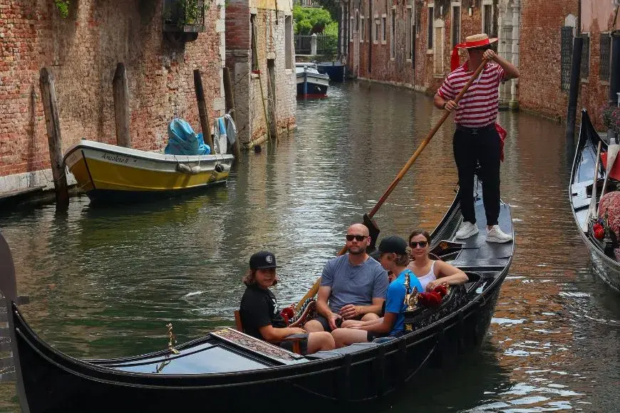 Venice Travel Guide, Classic gondola floating through a narrow Venice canal